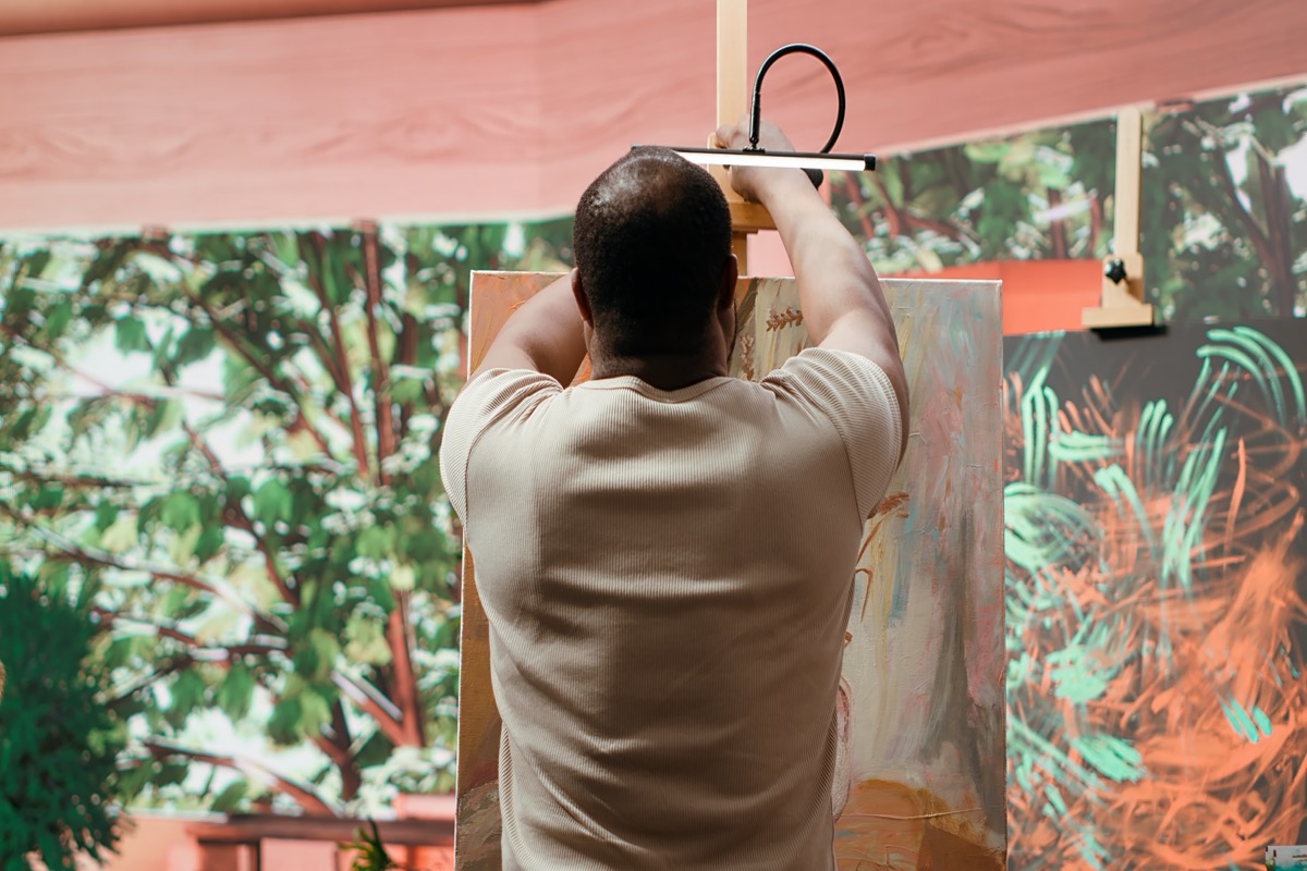 Artista trabajando en su estudio con pinturas y lienzos