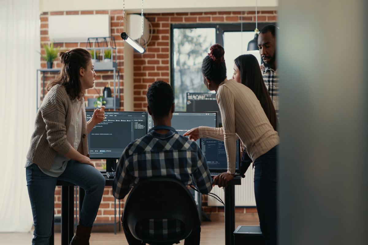 Equipo de desarrolladores trabajando en código en oficina moderna